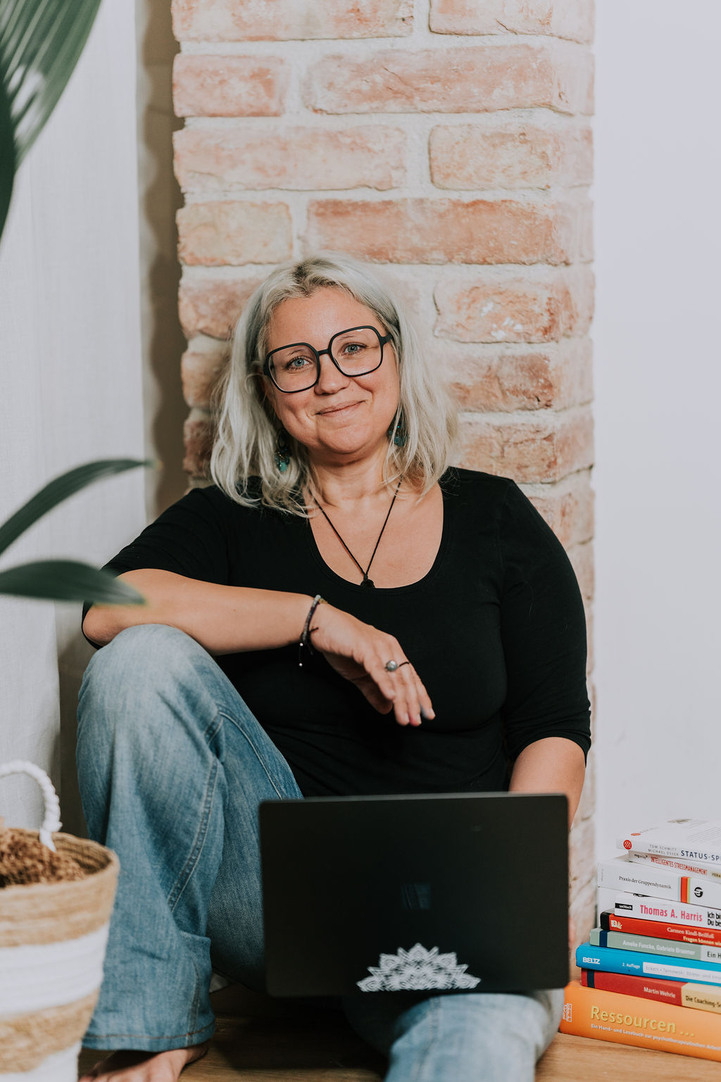 die-kommunikationsartistin-kerstin-schaefer-zimmermann-1000x1500-003-ker-81 Kerstin Schäfer-Zimmermann sitzt entspannt mit Laptop am Boden.